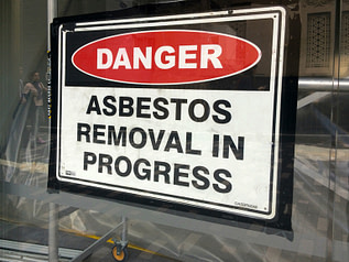 Sign reads: Danger - Asbestos removal in progress Sign reads: Danger - Asbestos removal in progress